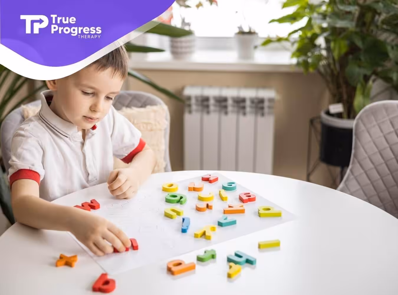 Autistic boy playing with colorful magnetic letters on a table indoors during ABA therapy.