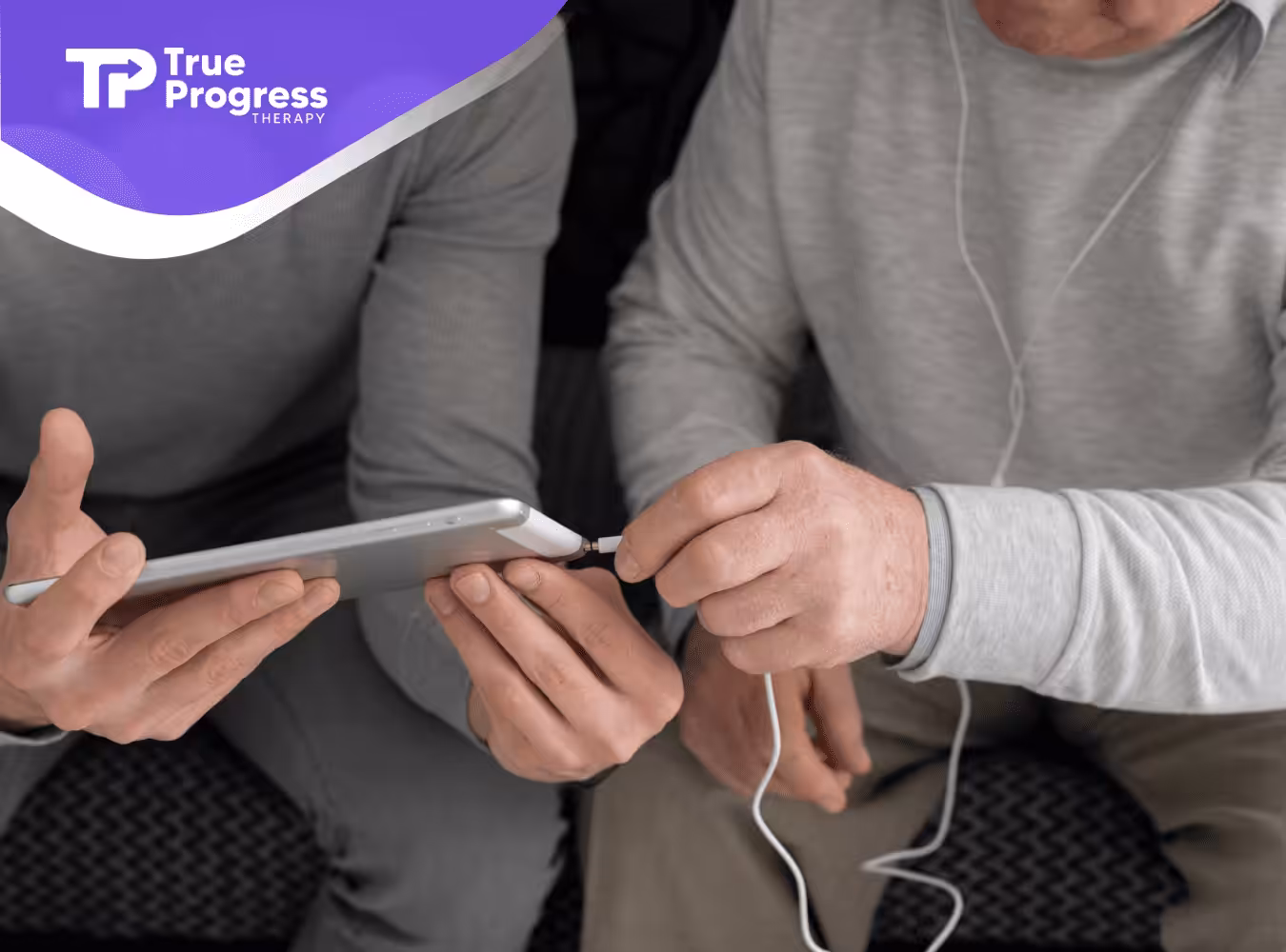 Two individuals with autism are holding a mobile phone