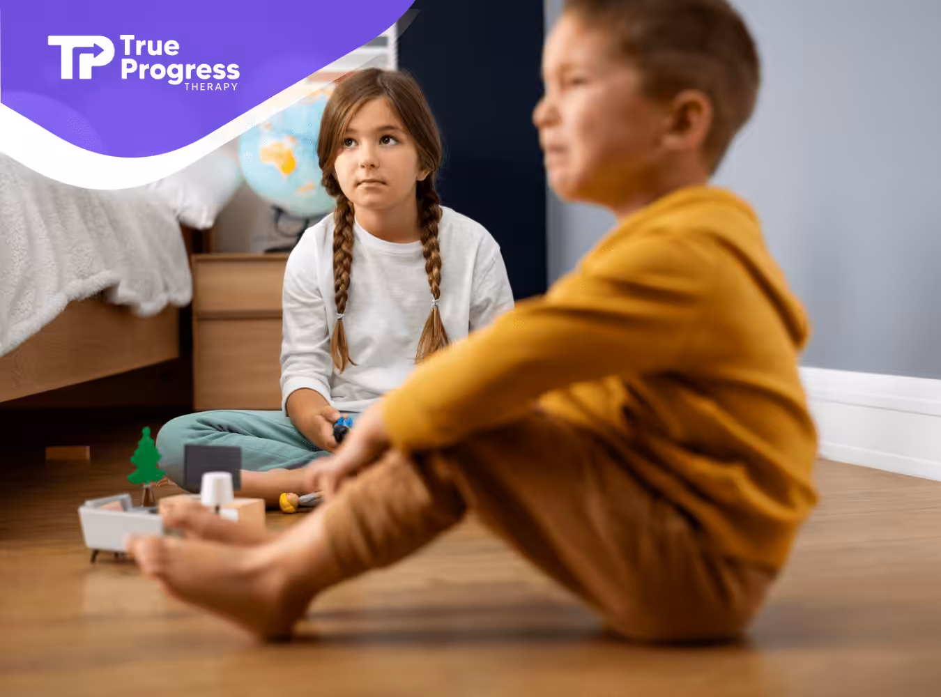 Two siblings sitting on the floor. One kid is crying.