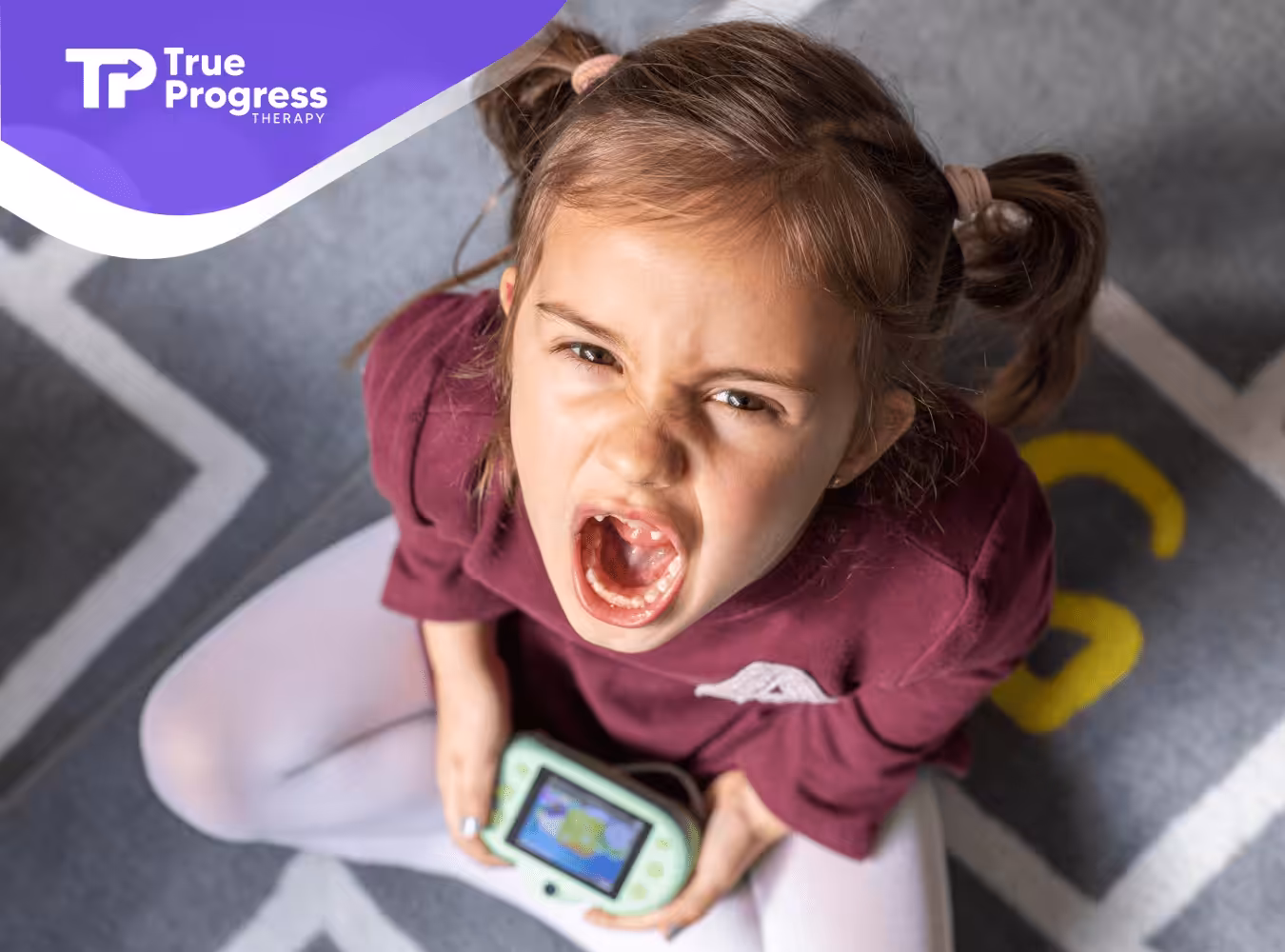 A child is screaming while throwing a tantrum during ABA therapy.