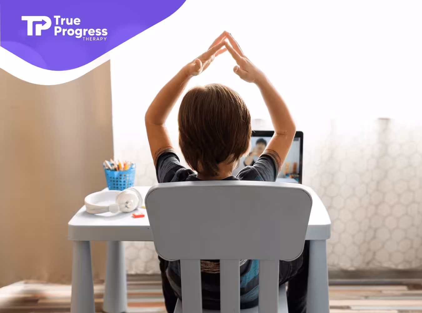 An autistic child sitting on a chair participating on an ABA activity online.