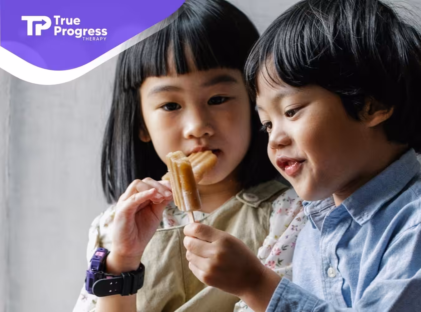 Two children with autism happily sharing an ice pop together at home in New Jersey.