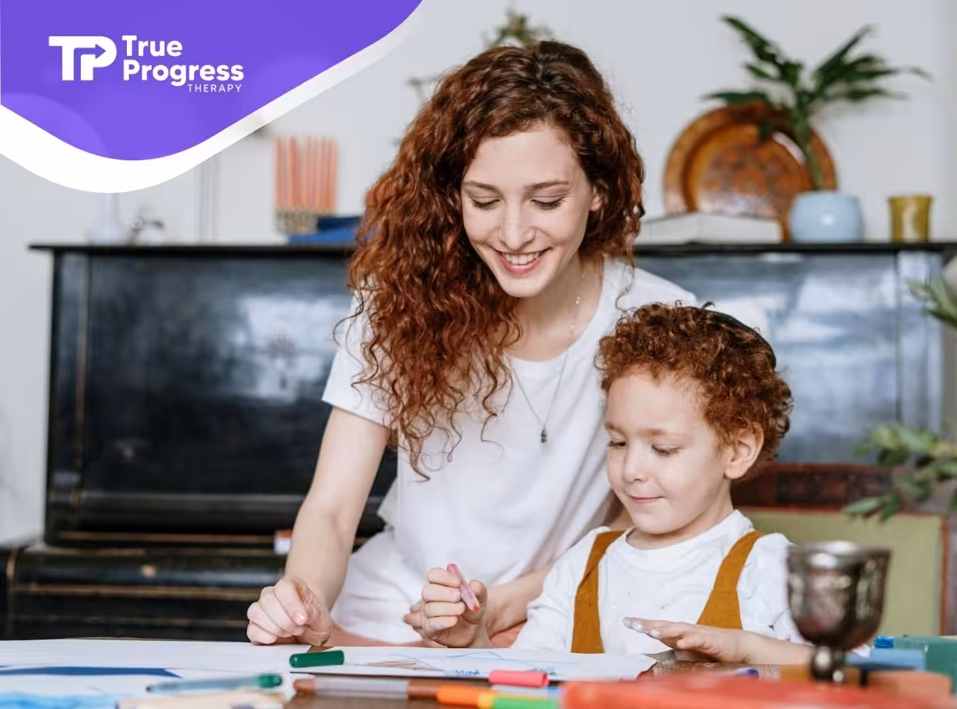 An ABA therapist helping child draw with crayons at a table during in-home ABA therapy in New Jersey.