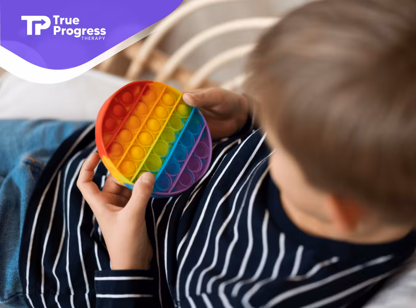 A kid with autism holding a colorful fidget toy