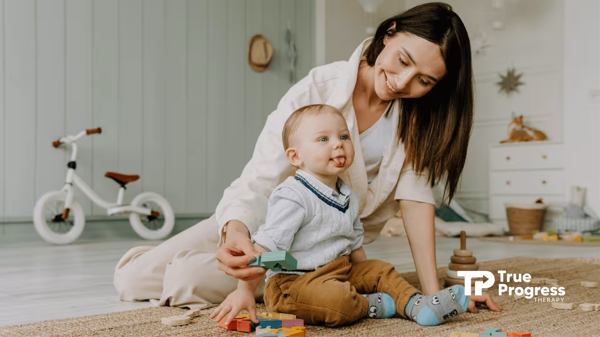 An ABA therapist playing on floor with autistic toddler and colorful blocks in a cozy room in New Jersey.