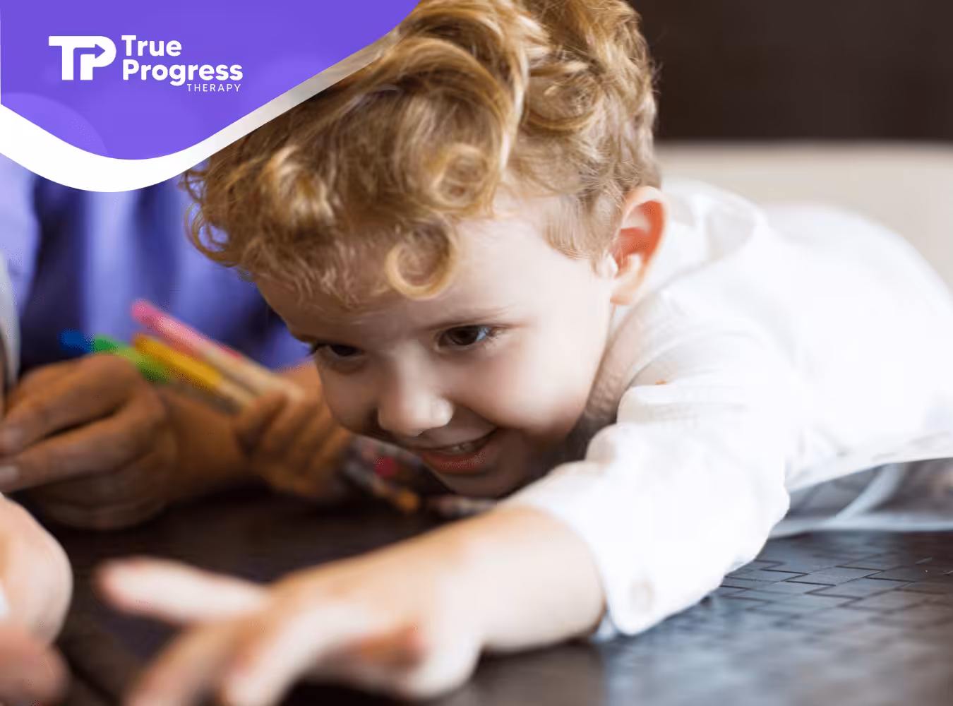 A kkid with autism leaning on a table