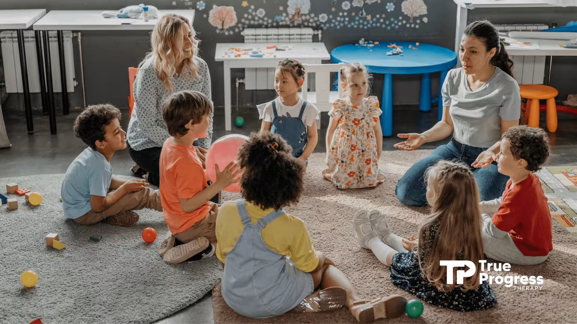 Group of young autistic children sitting in a circle with an RBT and BCBA in a playroom in New Jersey.