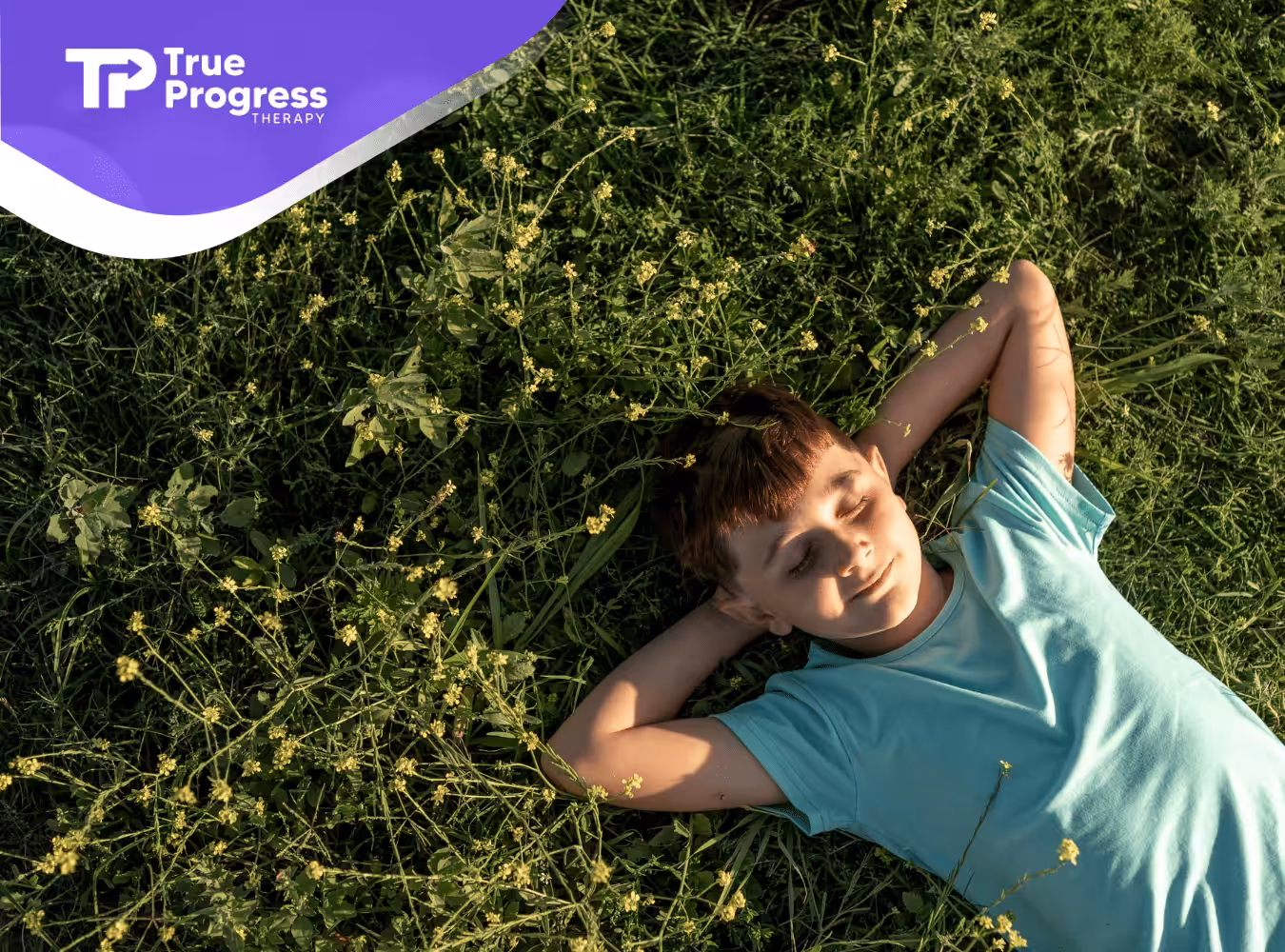 A kid with autism laying on the grass