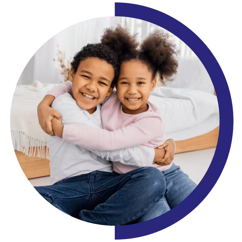Two children sharing a joyful hug during in-home ABA therapy