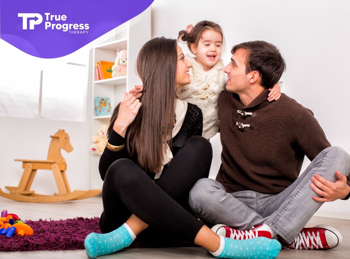 A family playing together on the floor.