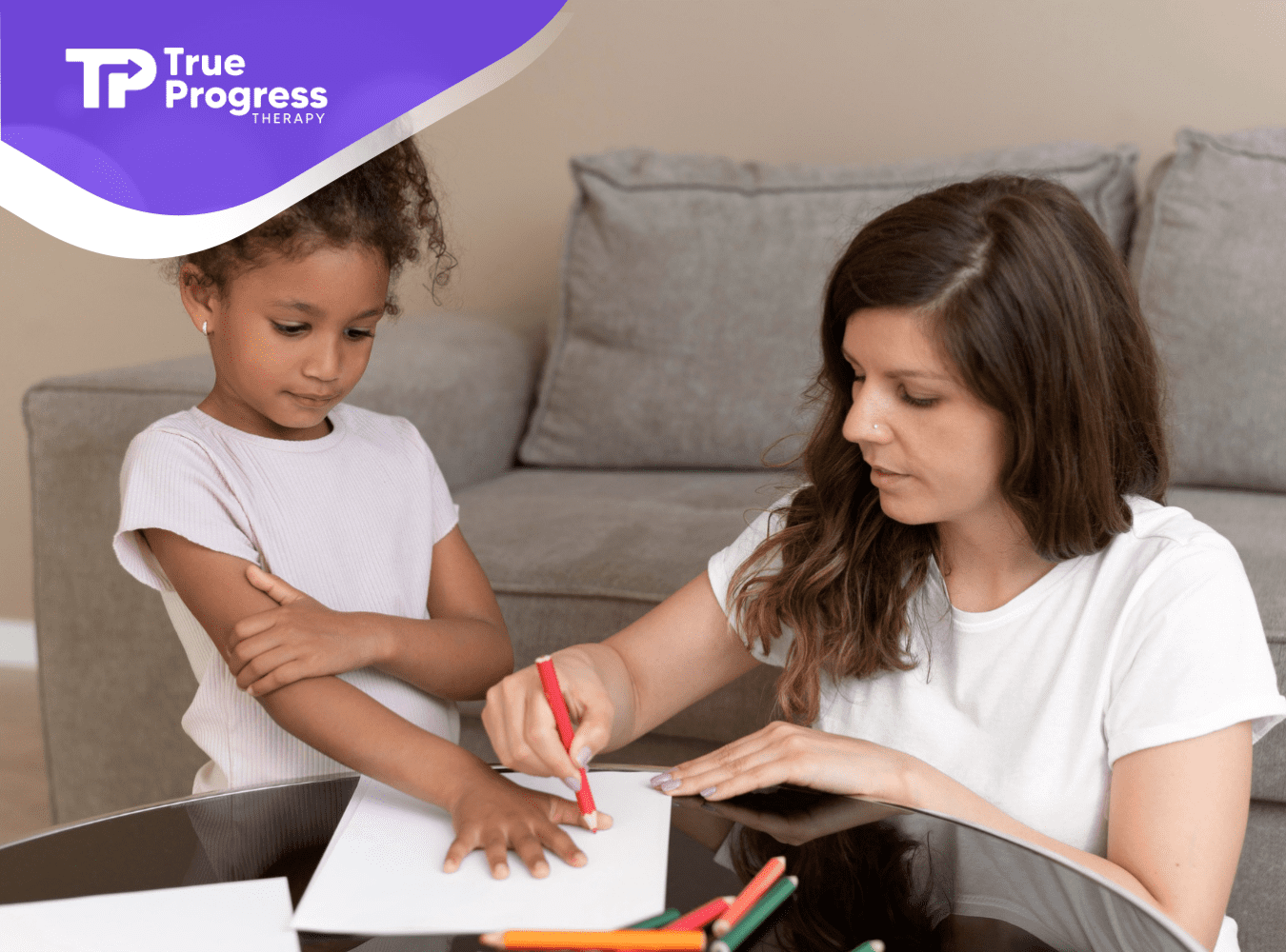 A therapist guiding a child in a drawing activity.