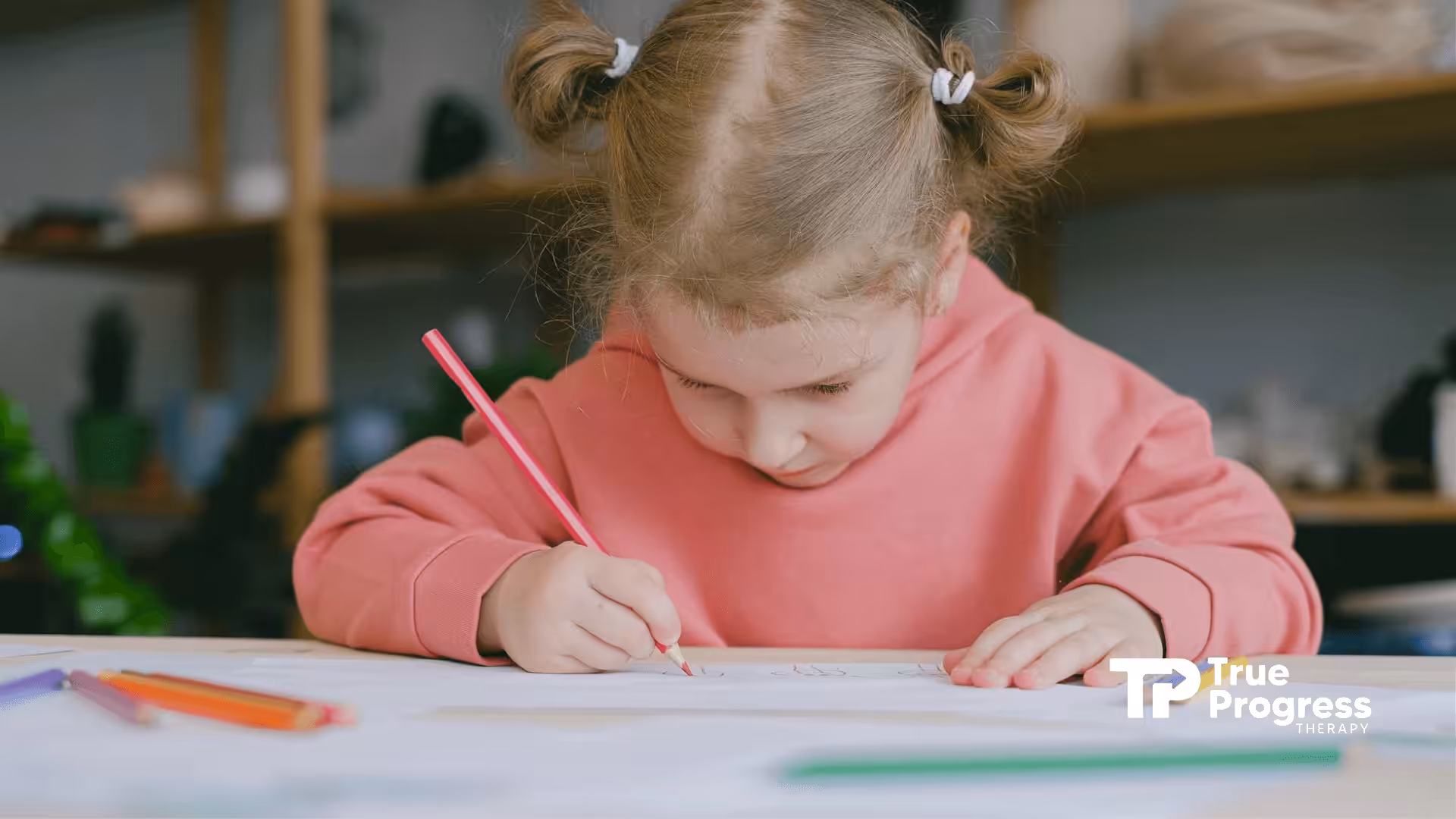 A girl with autism concentrating on her drawing at a table filled with pencils in New Jersey.