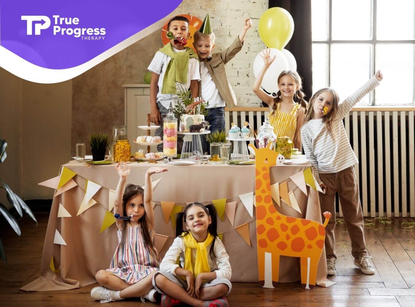 Group of children with autism celebrating at a decorated birthday party table.