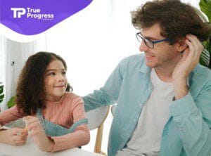 A BCBA and a young girl sitting at a table in ABA therapy session in NJ.