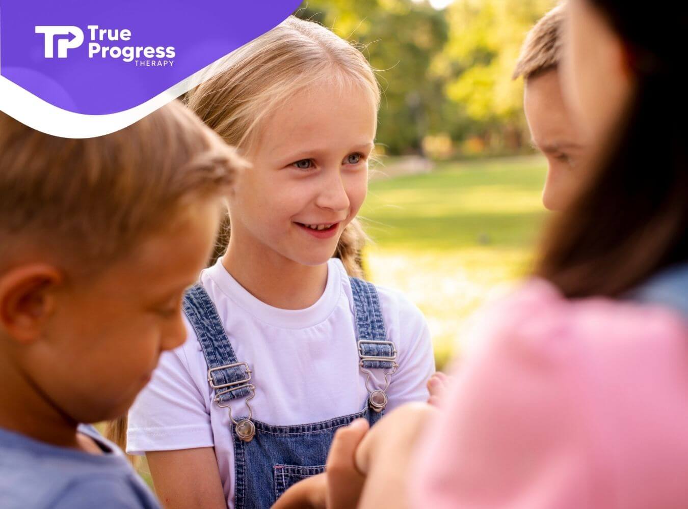 Group of children with autism standing outside, smiling and talking together.