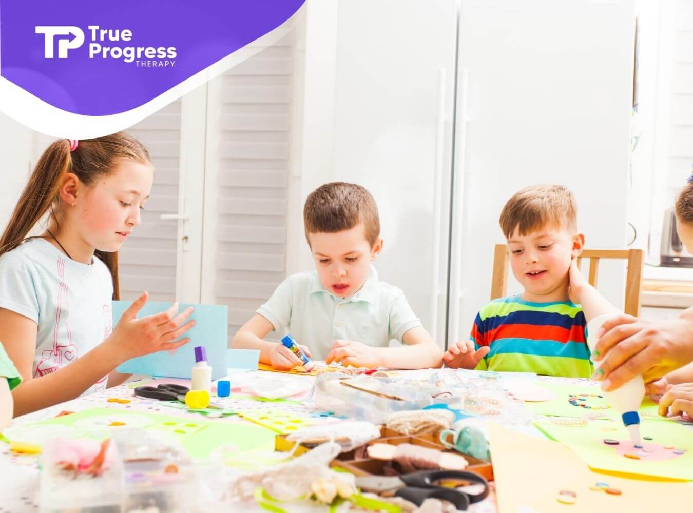Children with autism doing arts and crafts at table in ABA therapy.