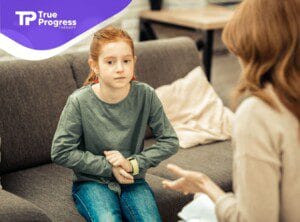 A child talking to a BCBA during ABA therapy.
