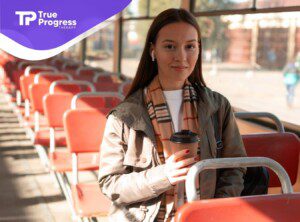 An autistic teen holding a coffee cup in a bus.