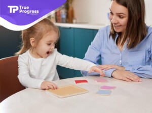 Child excitedly playing a color-matching game with a BCBA.