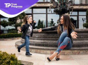 A child runs toward a BCBA with open arms outdoors.